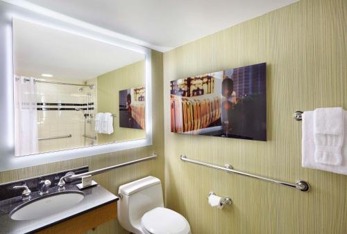 伊丽莎白希尔顿纽华克机场酒店的一间带卫生间、水槽和镜子的浴室