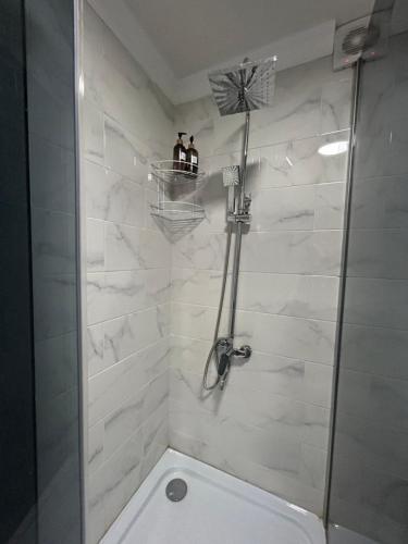奎兹洛达Уютная, светлая квартира-студия в районе Акмешит的带淋浴的浴室,两人站在架子上