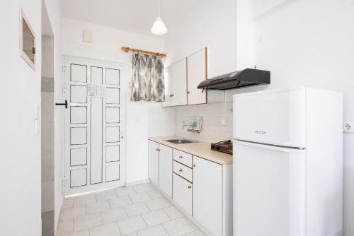 卢特拉艾季普苏Zoe Seaside的白色的厨房配有白色橱柜和冰箱。
