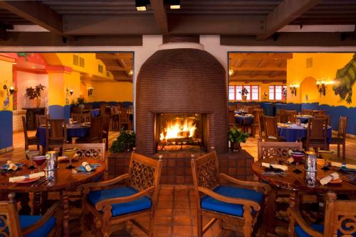 拉昆塔La Quinta Resort & Club, Curio Collection的中间设有1间带桌子和壁炉的餐厅