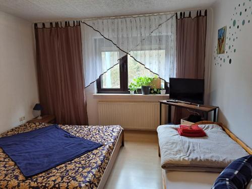 弗尔克林根Ferienwohnung Niklas的一间卧室设有两张床、一张桌子和一个窗口。