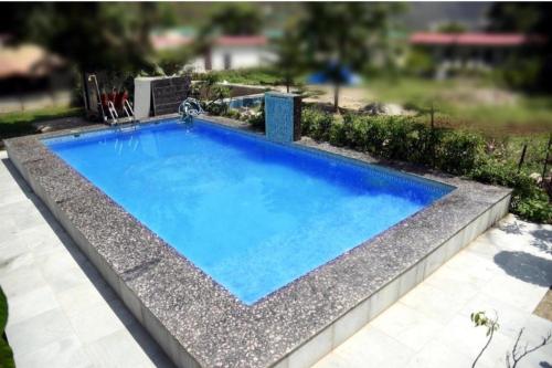BijniAstroia banjara tola camp的庭院里的一个蓝色海水游泳池