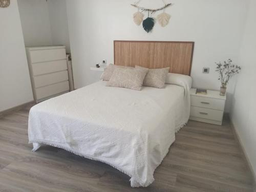 卡拉瓦卡·德·拉·克鲁斯Casa para relajarse, con vistas.的卧室配有白色的床和木制床头板