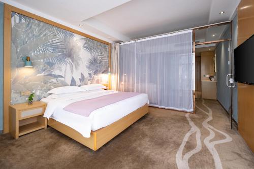 厦门厦门舒悦酒店的一间卧室配有一张大床和壁画