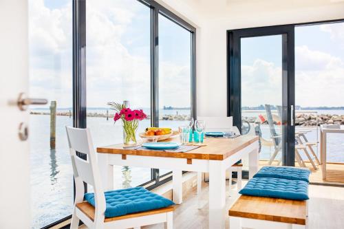 艾恩松Hausboot WELL - Husbåd WELL的一间配备有桌子的用餐室,享有水景