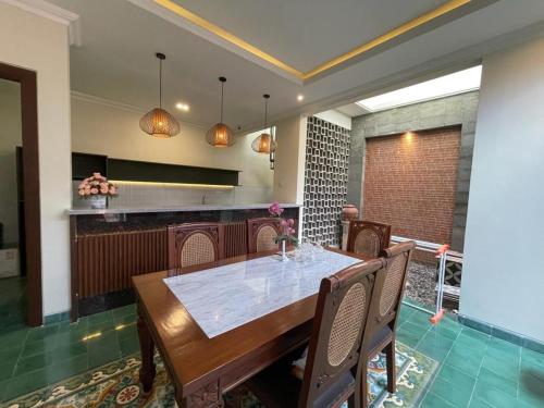 LaweanGuesthouse Syariah Griya Truntum的厨房里设有1间带桌椅的用餐室