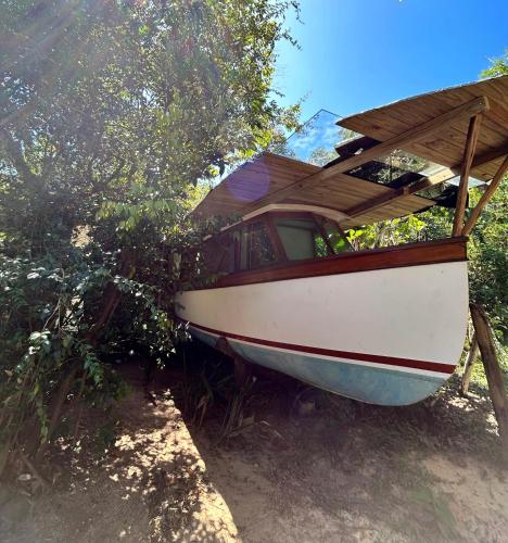 弗洛里亚诺波利斯Casa Barco Campeche的坐在树旁的地面上的船
