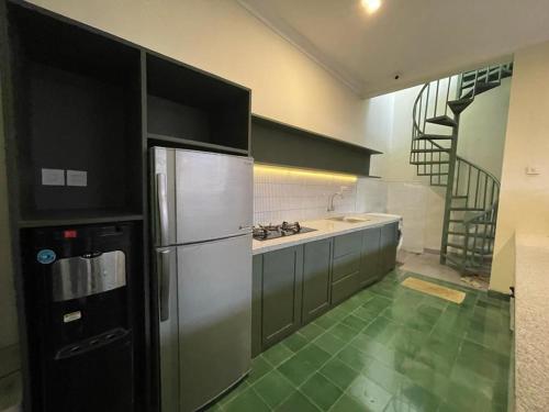 LaweanGuesthouse Syariah Griya Truntum的厨房配有不锈钢冰箱和楼梯