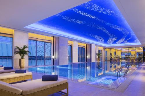 济宁济宁富力万达嘉华酒店的蓝色天花板建筑中的游泳池