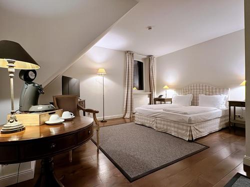 LüdersburgSchloss Lüdersburg Golf & Spa的一间卧室配有一张床、一张桌子和一张桌子