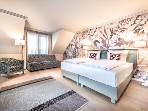 汉堡翰堡特瑞德尔伯格施泰根博阁酒店的一间卧室配有一张大床和一张沙发