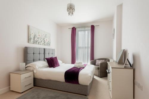 红山Queens Lodge 1-Bed Apartment in Redhill的一间卧室配有一张大床和一把椅子