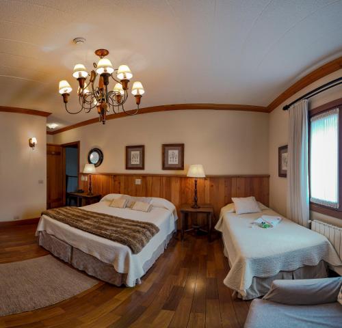 坎波斯杜若尔当Hotel Solar d'Izabel的酒店客房设有两张床和吊灯。