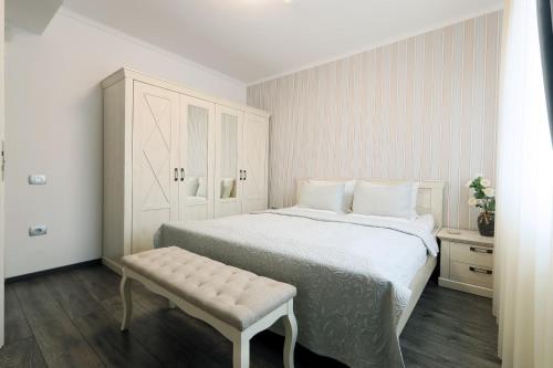 奥拉迪亚Olivia Home的白色卧室设有一张大床和长凳