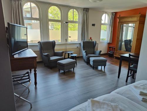 波尔代克圣文森特酒店的一间带椅子、一张床和电视的房间