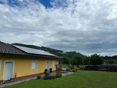 WietingFerienhaus mit Terrasse und viel Ruhe的黄色的房子,有桌子和火车