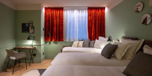 米兰Urban Hive Milano的一间卧室设有两张床,窗户配有红色窗帘
