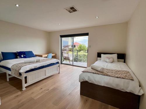 霍巴特Hobart View的一间卧室设有两张床和滑动玻璃门