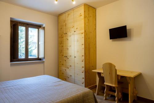 拉奎拉La Villetta Food & Drink Rooms for Rent - No Reception -的一间卧室配有一张床、一张书桌和一个橱柜