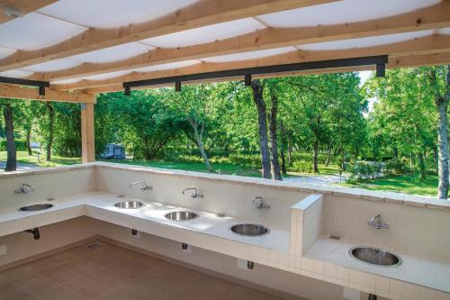 波雷奇Istra Sunny Tent in Lanterna Premium Camping Resort 4*的一间带三个盥洗盆的浴室和一个大窗户