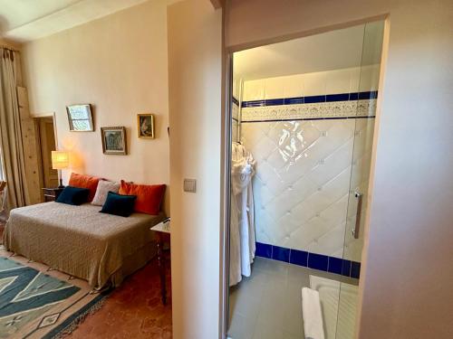 佩兹纳斯Château de Roquelune的一间卧室设有一张床和一个玻璃淋浴间