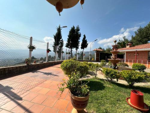 拉基拉Finca Villa Maria - Cabaña的一个带植物和栅栏的庭院和一座房子