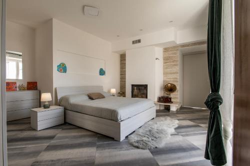 阿斯蒂Casa del Rosmarino的一间白色卧室,配有一张床和一个壁炉