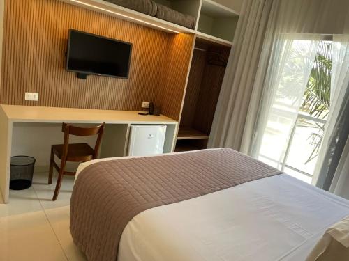 雅尔丁Hotel Jardim的一间卧室配有一张床、一张书桌和一台电视