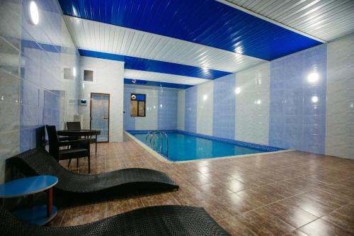 撒马尔罕GRAND HOTEL SOGDIANA的一个带桌子和用餐室的大型游泳池
