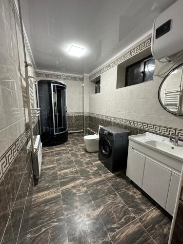 BagyshGuest House Alym-Ata的浴室配有卫生间水槽和洗衣机。