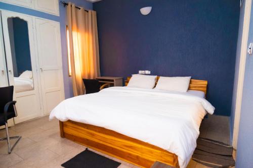 洛美Studio cosy et confortable的一间卧室设有一张蓝色墙壁的大床