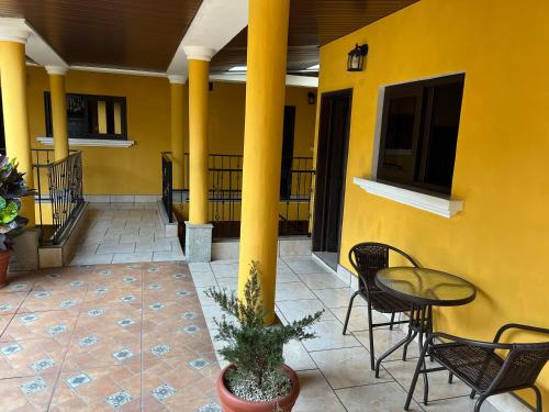 科万Casa Alegria的一座黄色的建筑,庭院里设有椅子和桌子