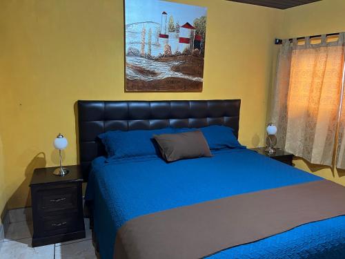 科万Casa Alegria的卧室配有蓝色的床和墙上的绘画作品