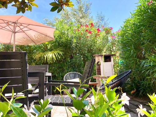 加尔达湖滨Appartamento villatorretta24的庭院设有椅子和遮阳伞,鲜花盛开