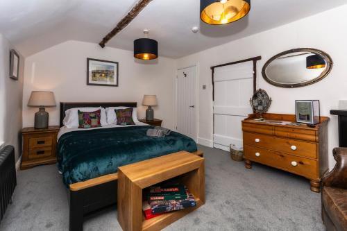 布由德利The Clockhouse Bewdley的一间卧室配有一张床、梳妆台和镜子