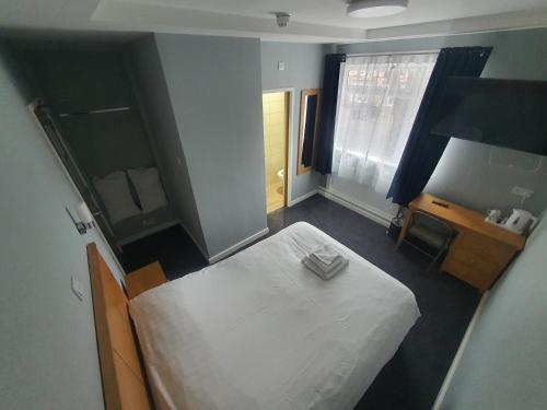 彼得伯勒Newark Hotel Peterborough的卧室配有白色的床和镜子