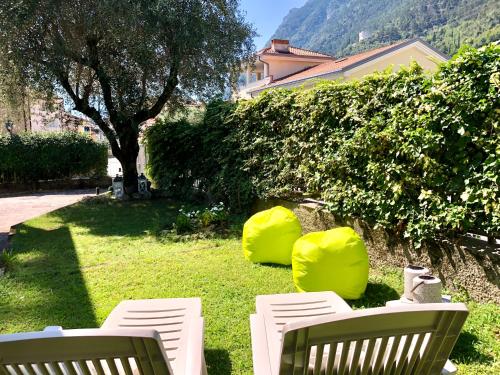 加尔达湖滨Appartamento villatorretta24的两把白色椅子坐在草坪上,上面有树