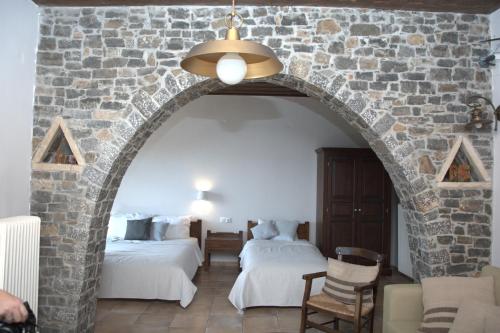 TzermiádonΑργουλιάς的一间设有两张床和石墙的房间