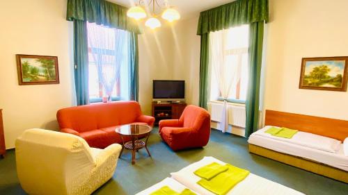 赫拉德茨 - 克拉洛韦塞尔尼昆膳食公寓的客厅配有椅子、沙发和电视