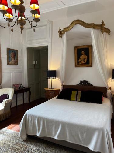 伊苏丹Le Logis de Saint Cyr的卧室配有一张白色大床和一把椅子