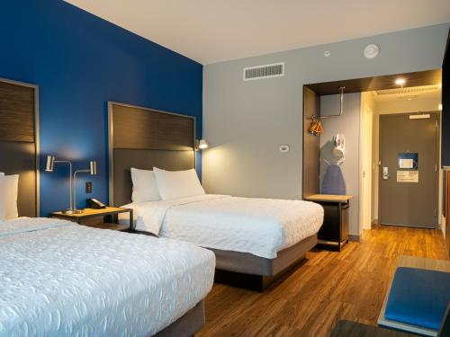亚特兰大Tru By Hilton Atlanta Airport College Park的两张位于酒店客房的床,拥有蓝色的墙壁