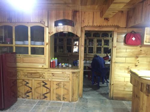 PhakdingTribeni Lodge Restaurant And Bar的厨房配有木制橱柜和桌子。