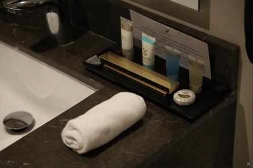 阿可贺巴Dream Residence Khobar的浴室内柜台上的毛巾和其他物品