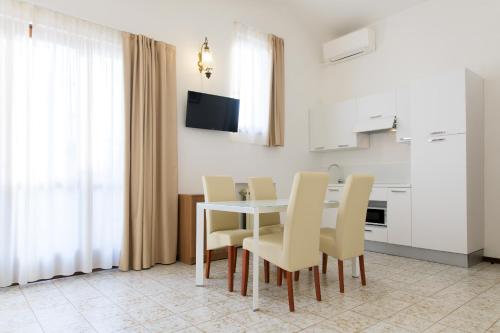 利莫内-苏尔加达Residence Oasi的一间配备有白色桌椅的用餐室