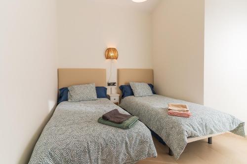 厄尔-汝姆披多Pareado con piscina en el Rompido的一间卧室配有两张床和一盏灯