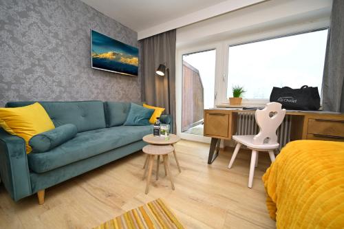 希洛谢克Alp-Chalet的客厅配有蓝色的沙发和床。