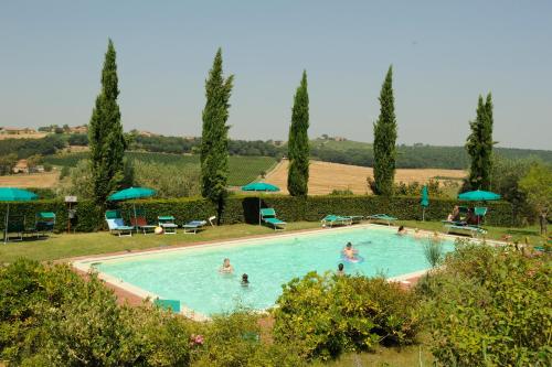 瓦里亚诺福气农庄旅馆的一座游泳池,里面的人种有树木和遮阳伞