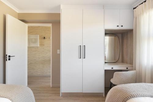 布鲁堡史特兰Coral Island 204的一间卧室配有两张床和白色橱柜