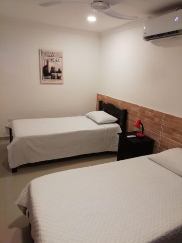 卡塔赫纳Apto amoblado barrio Los Alpes Cartagena的酒店客房设有两张床,墙上挂着一张照片。