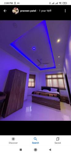 PrayagrajAbhinandan House stay的客房设有两张床和蓝色的天花板。